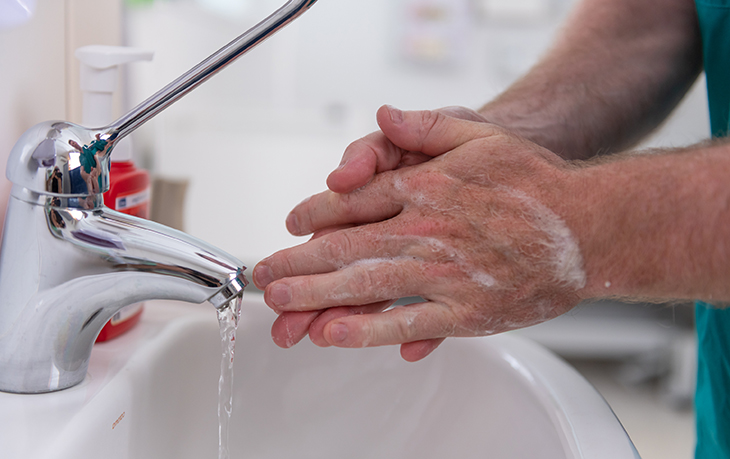 A person washes their hands with soap and water