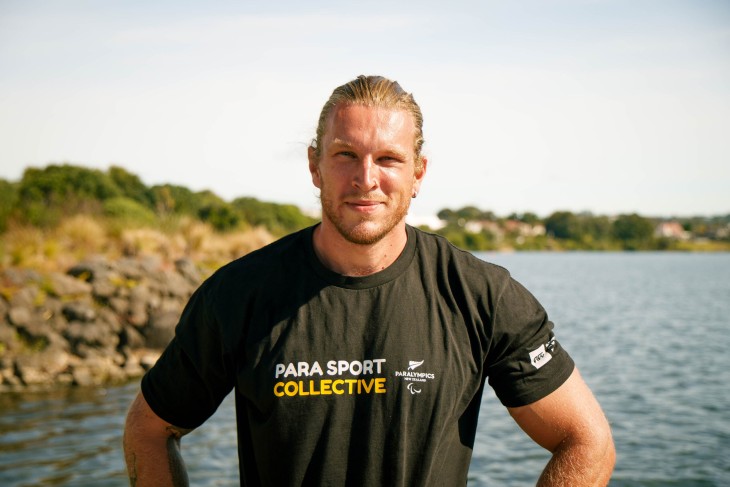 A close-up photo showing Finn Murphy standing in front of a lake.