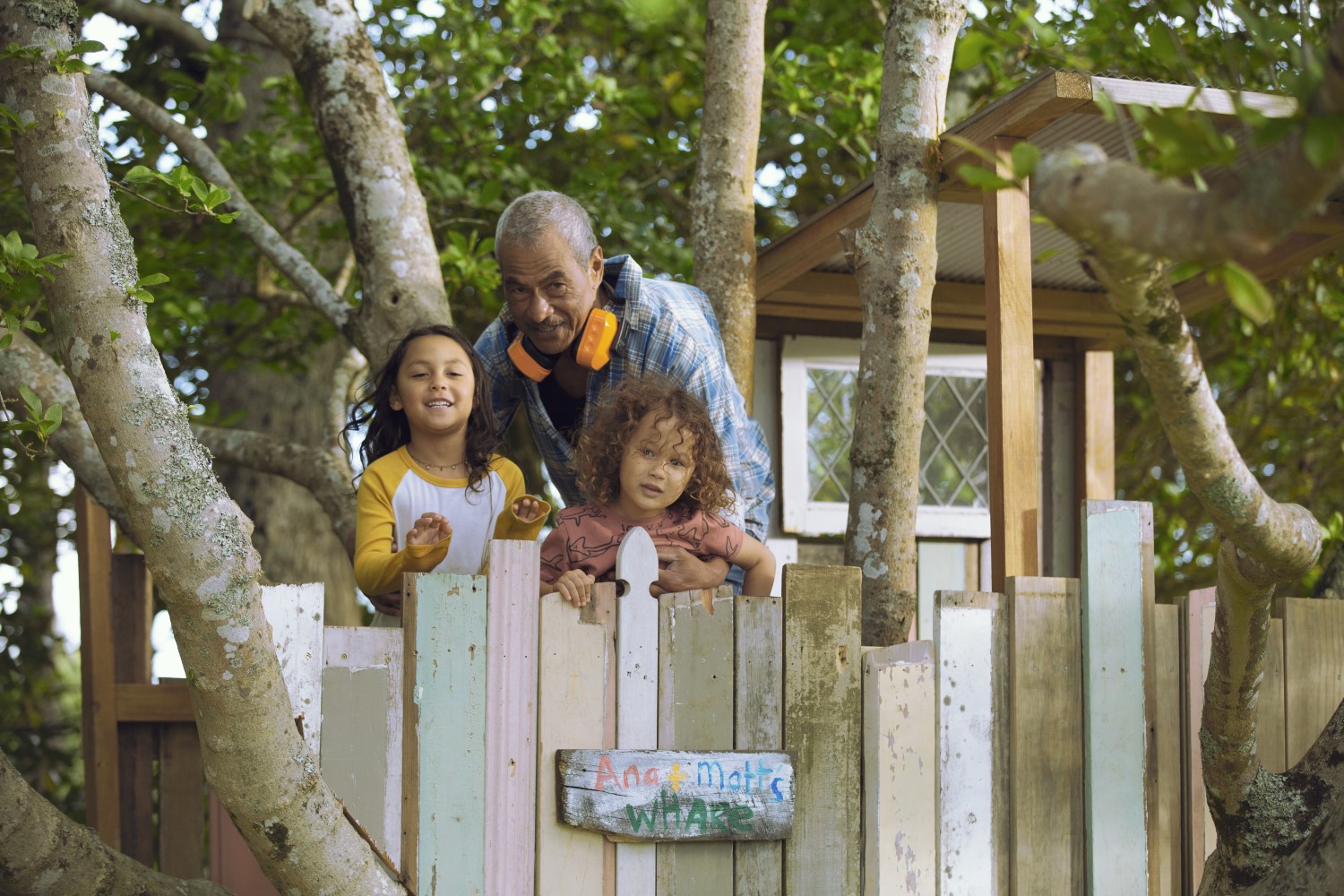 Grandfather and grandchildren in backyard