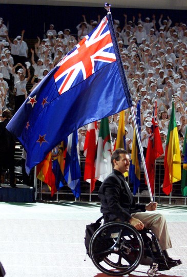 Ben Lucas carries the New Zealand flag into the Paralympic games