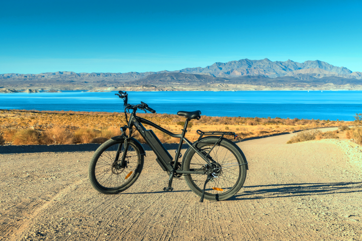 An ebike sits with a landscape of hills in the background