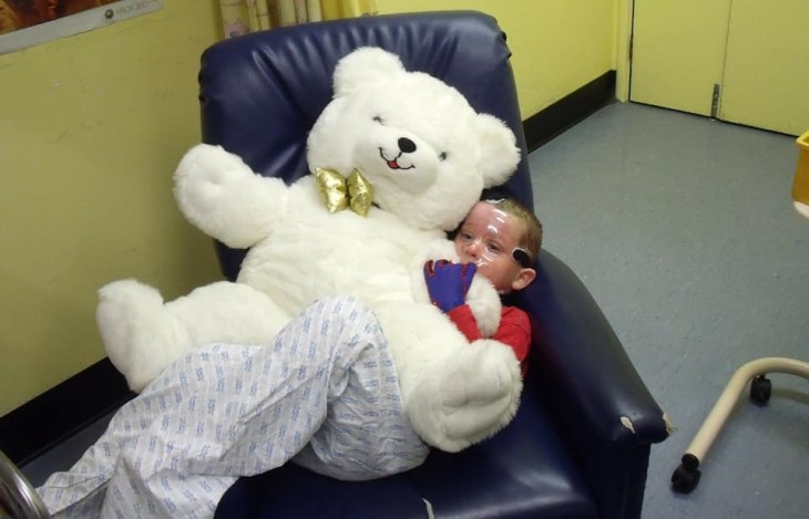 Young Brayden hugs a teddy bear as he is in hospital