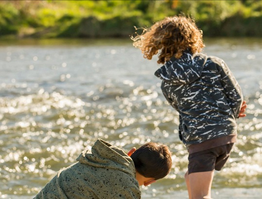 Children skipping stones on a river