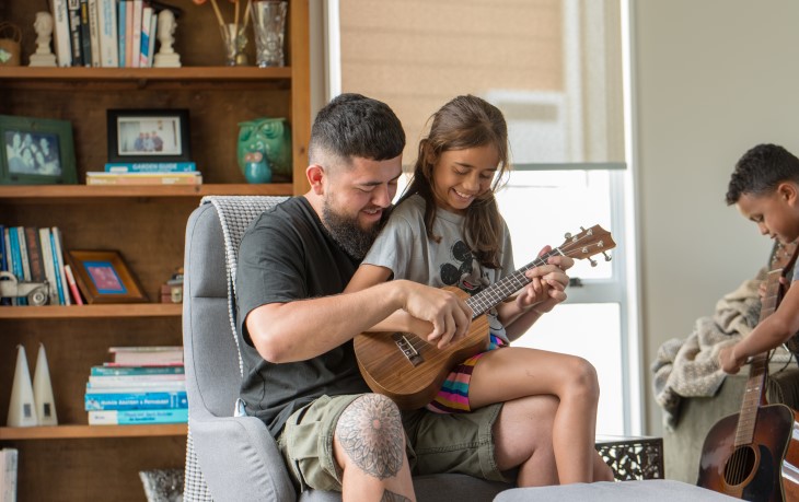 Father teaches daughter to play guitar