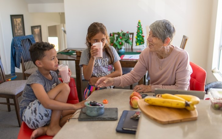 Grandma drinks a smoothie with her grandkids