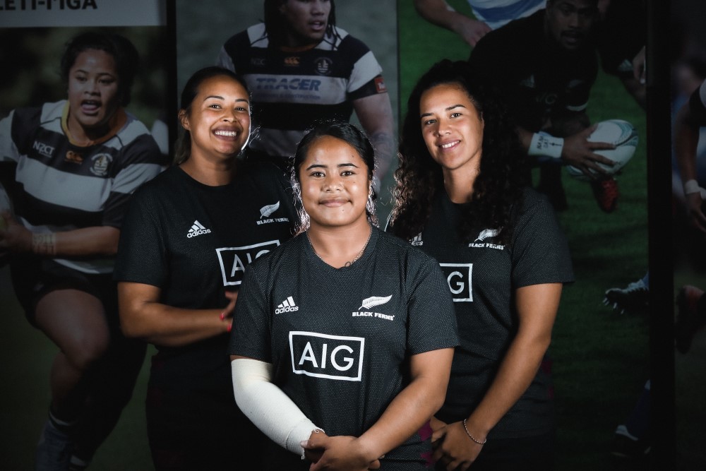 Three Black Ferns pose for a photo in their kit