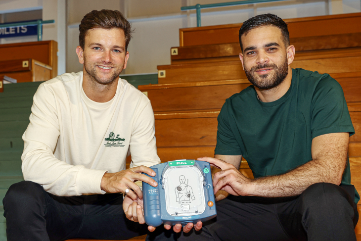 Josh and Kareem hold an AED unit