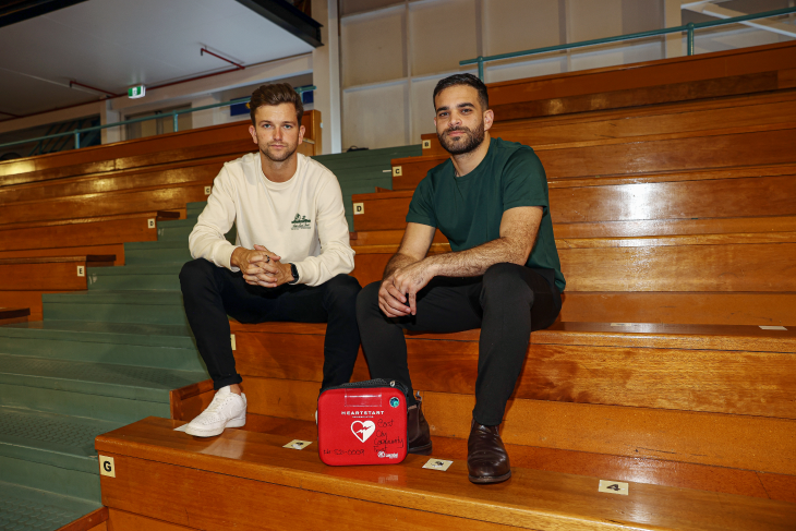 Josh and Kareem sit with an AED