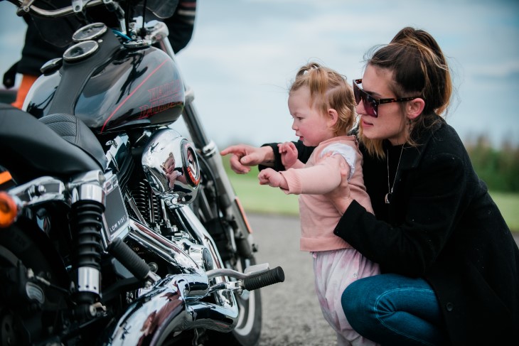 Kavana and her young daughter Harley look closely at a Harley Davidson motorbike