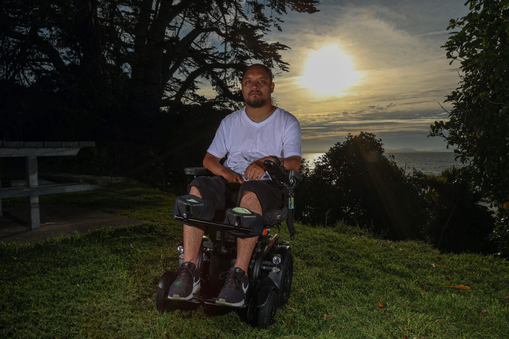Lee Taniwha sits in his wheelchair as the sun goes down behind him