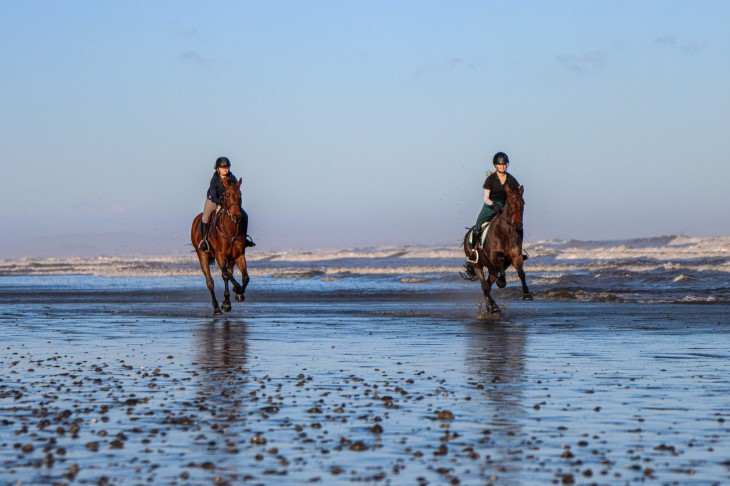 Lenka and her daughter Paris ride their horses on the beach