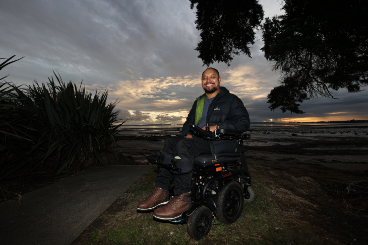 Lee parks his wheelchair by the shore at dusk