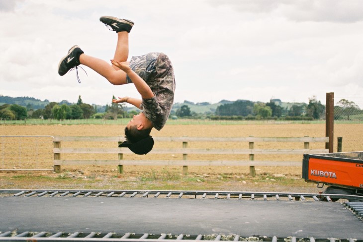 A kid does a flip on the trampoline