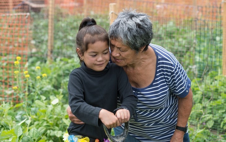 Older Pacifica women with child in garden