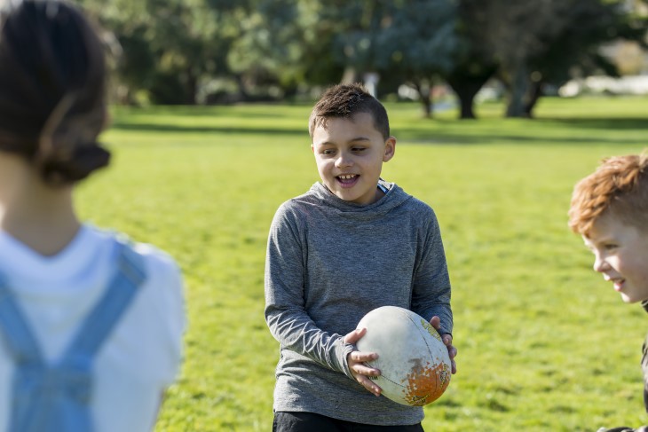 Young kids play with rugby ball