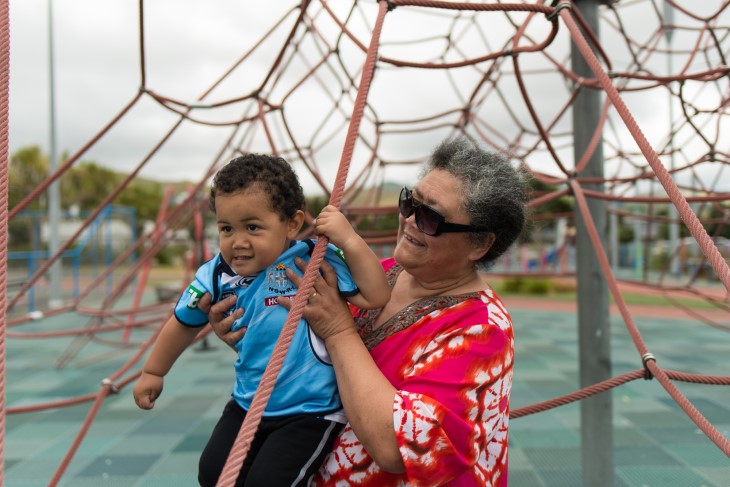 Grandmother plays with her grandson on the playground