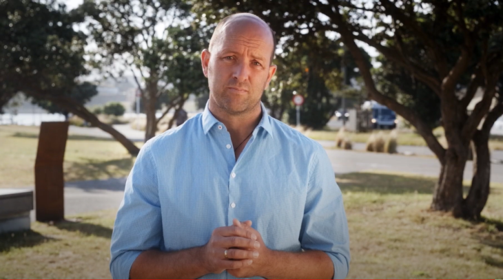 James Whitaker looks into the camera in a park