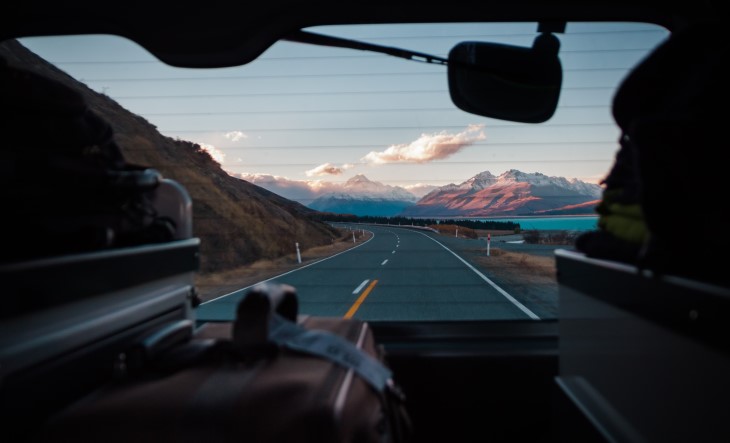 shot of road from inside car backseat showing mountains in the distance