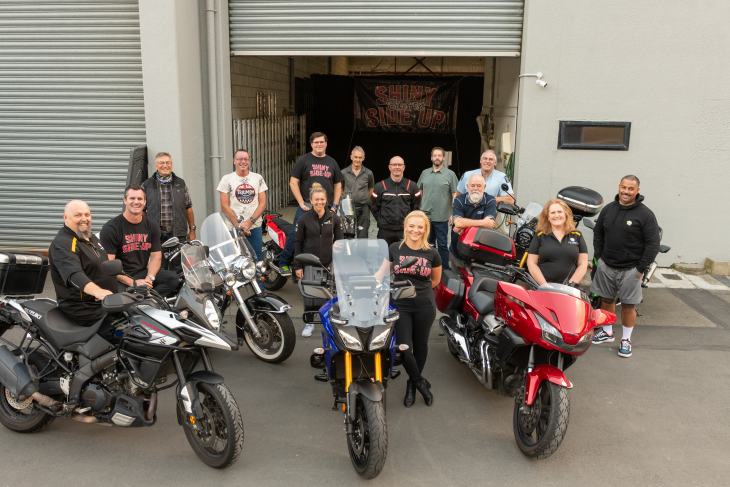 Riders and their bikes look up at the camera