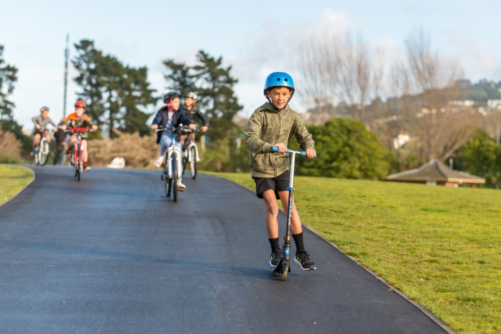 Tamariki bike and scooter along a footpath