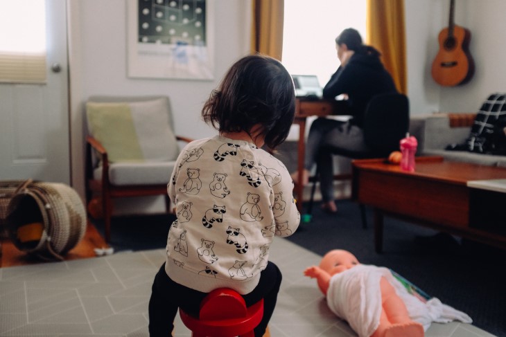 Child plays while mum works in background