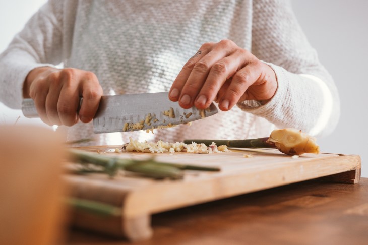 Person chops ginger with big knife