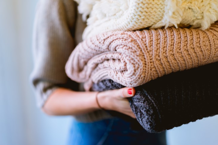 Woman carries winter jumpers
