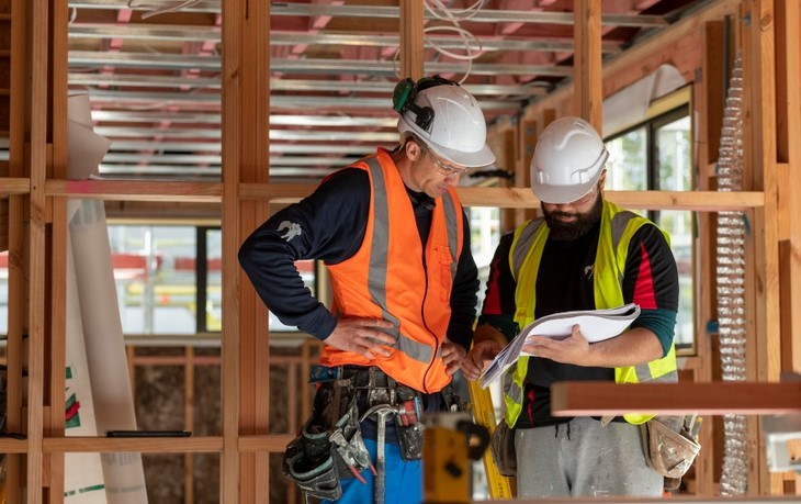 Two builders look at plans