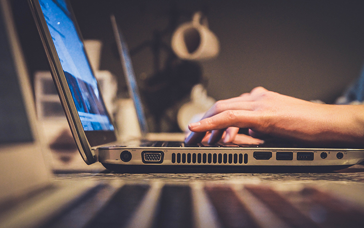 Hands typing on laptop