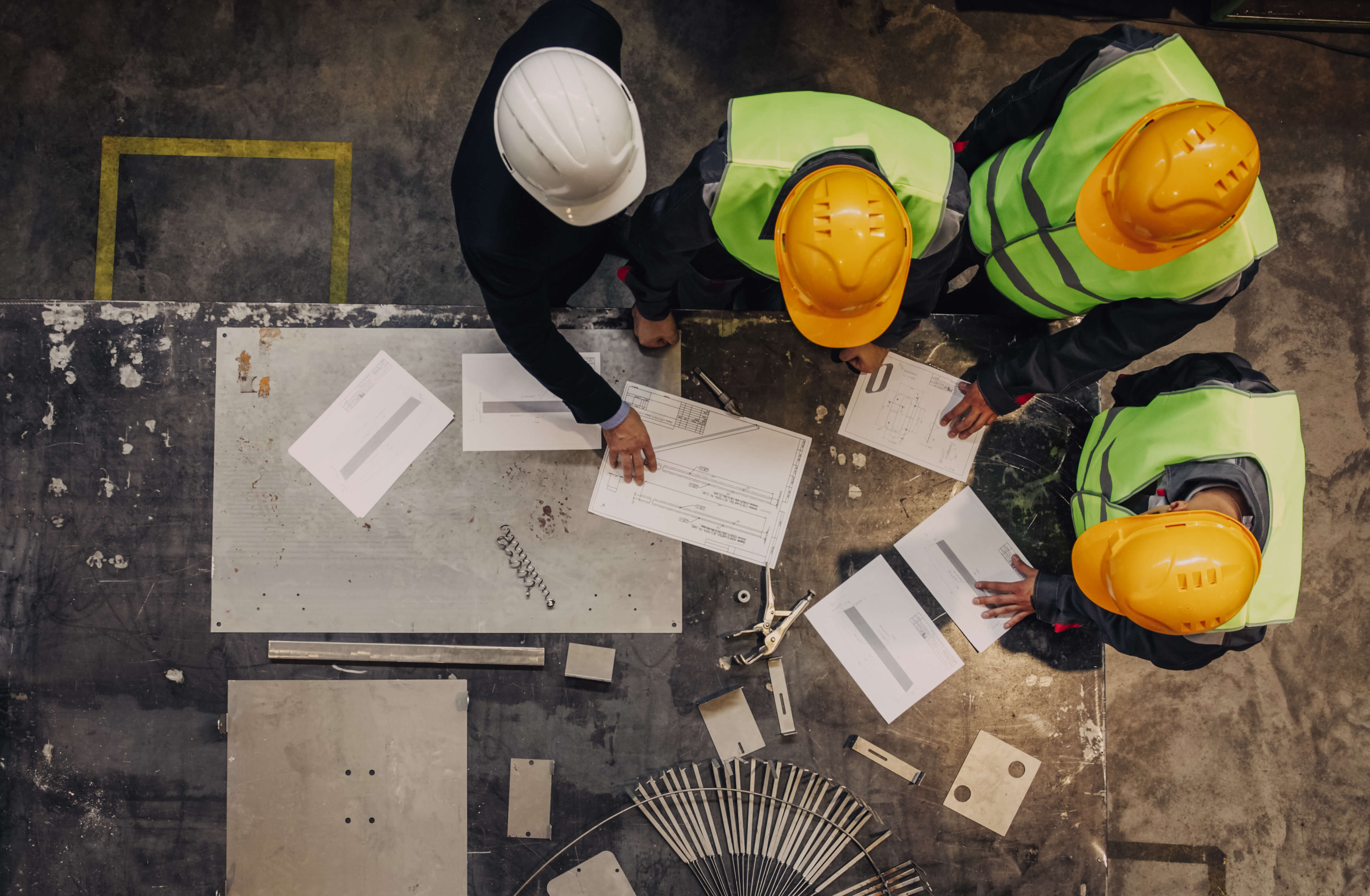 Men standing around a table looking at papers