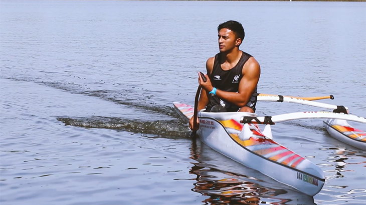 Peter Cowan in his outrigger canoe on a lake. 