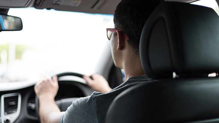 A young person learns to drive.