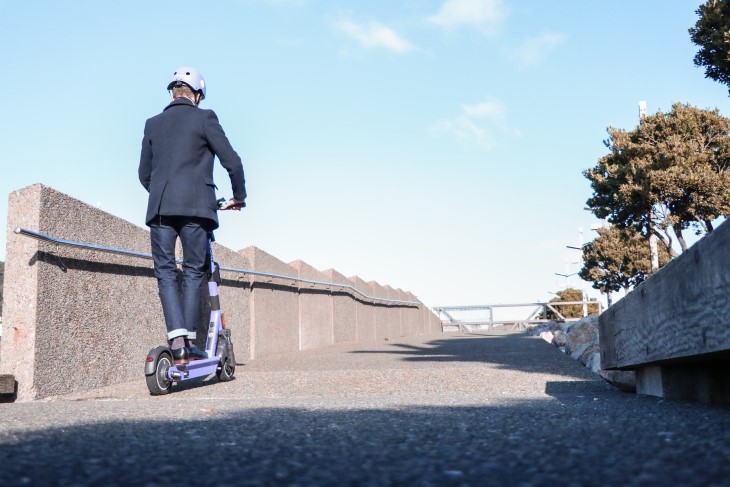 Man rides e-scooter up ramp