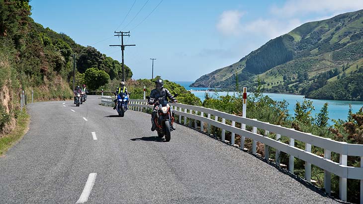 Group of motorcyclists ride down a road