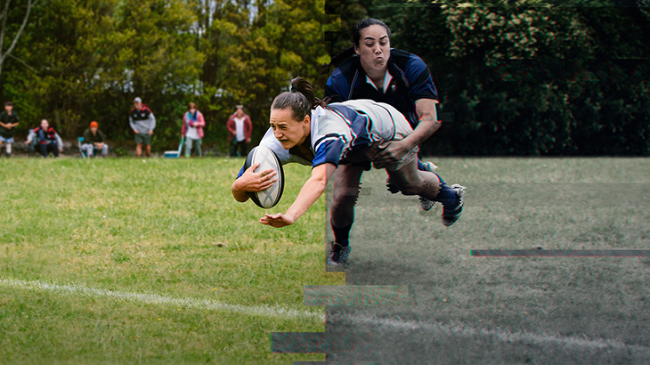 Woman scoring a try and being tackled