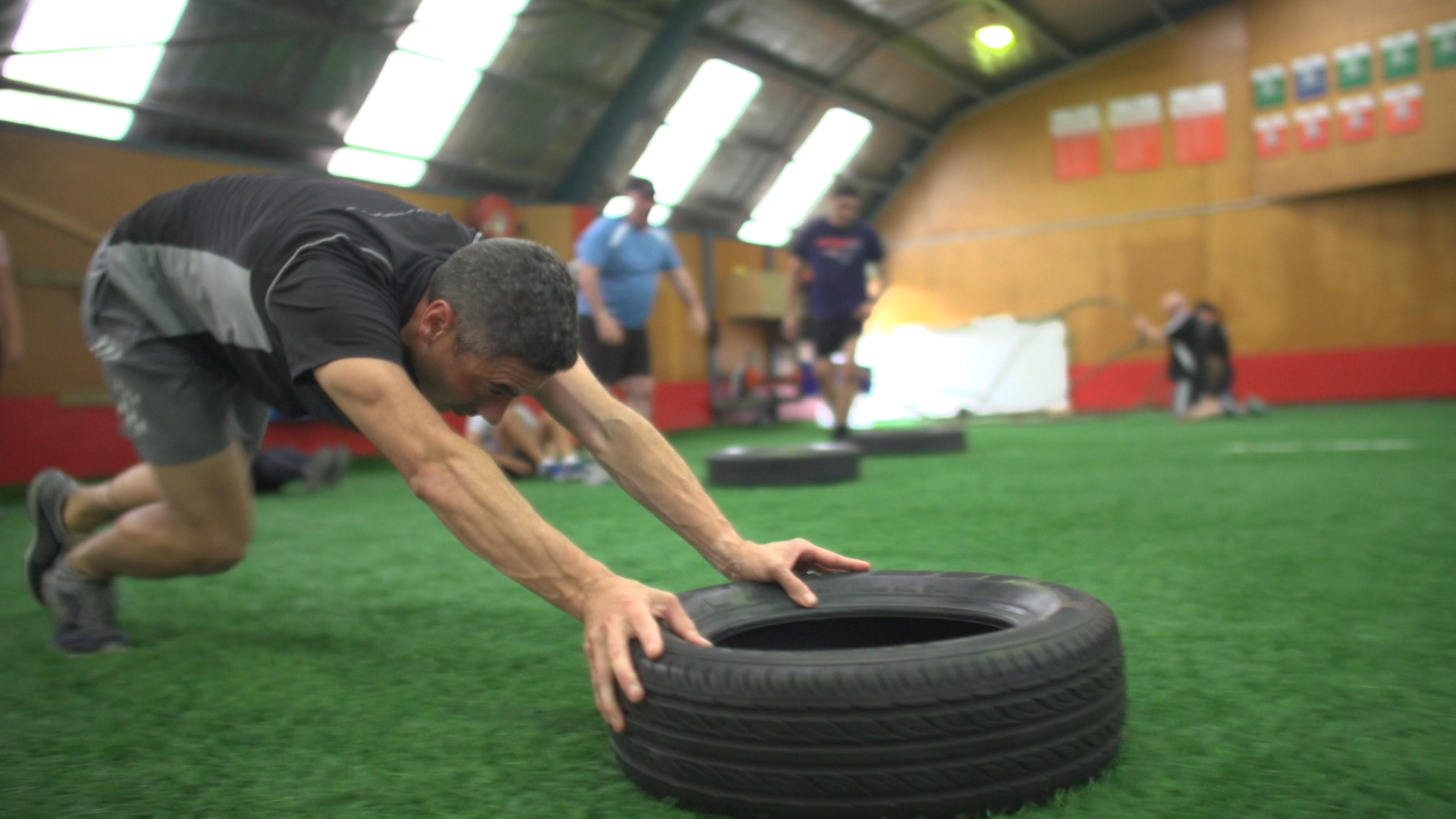 Ruku Rarere pushes a tyre across the floor