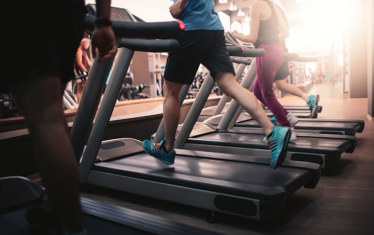 A group of people running on treadmills at the gym