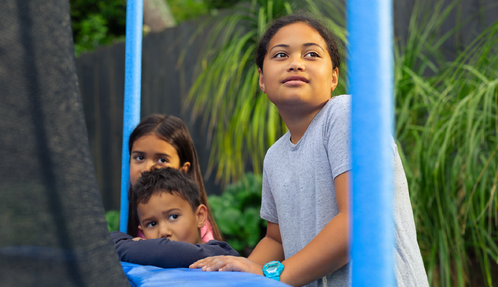 Tamariki standing by trampoline