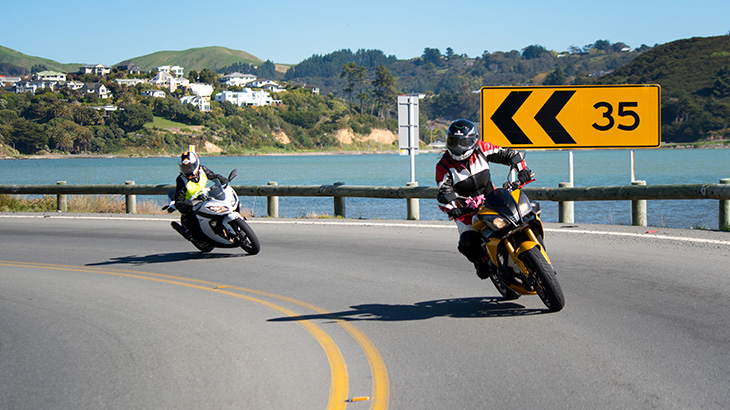 two motorcycle riders on a corner