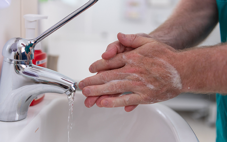 Wash your hands A person washes their hands with soap and water