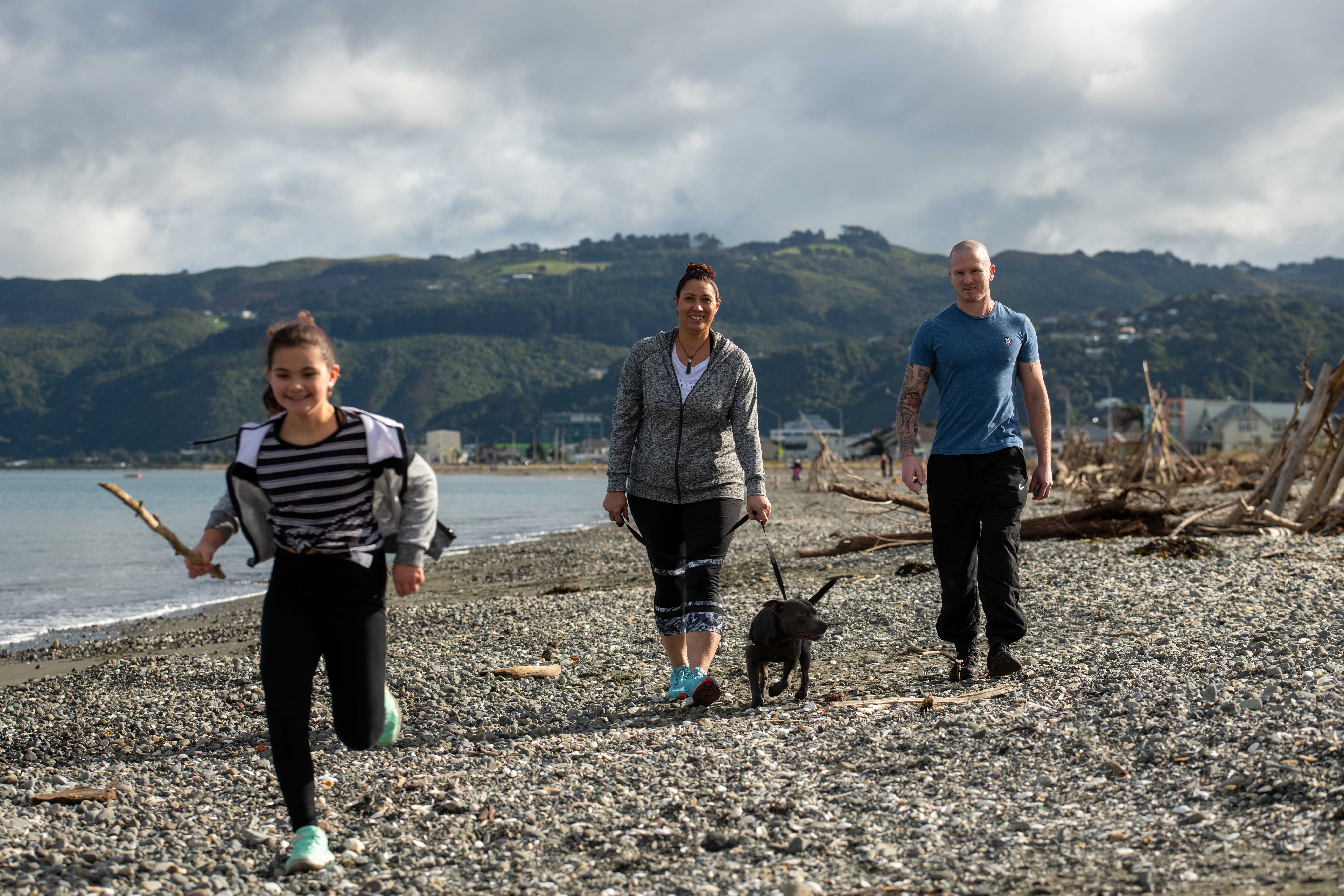 Two adults and child walking on beach