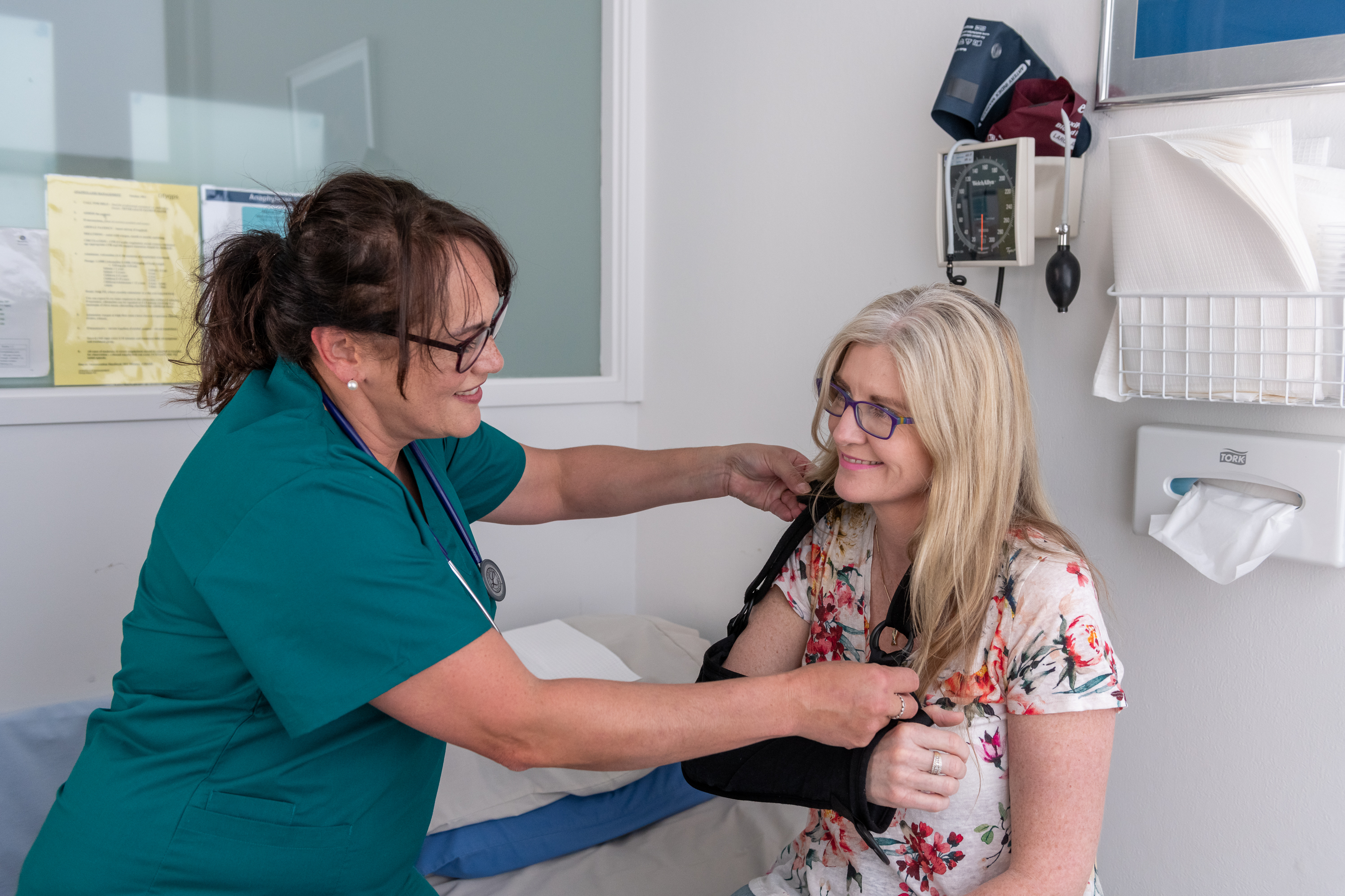 Health provider checking patient's shoulder mobility