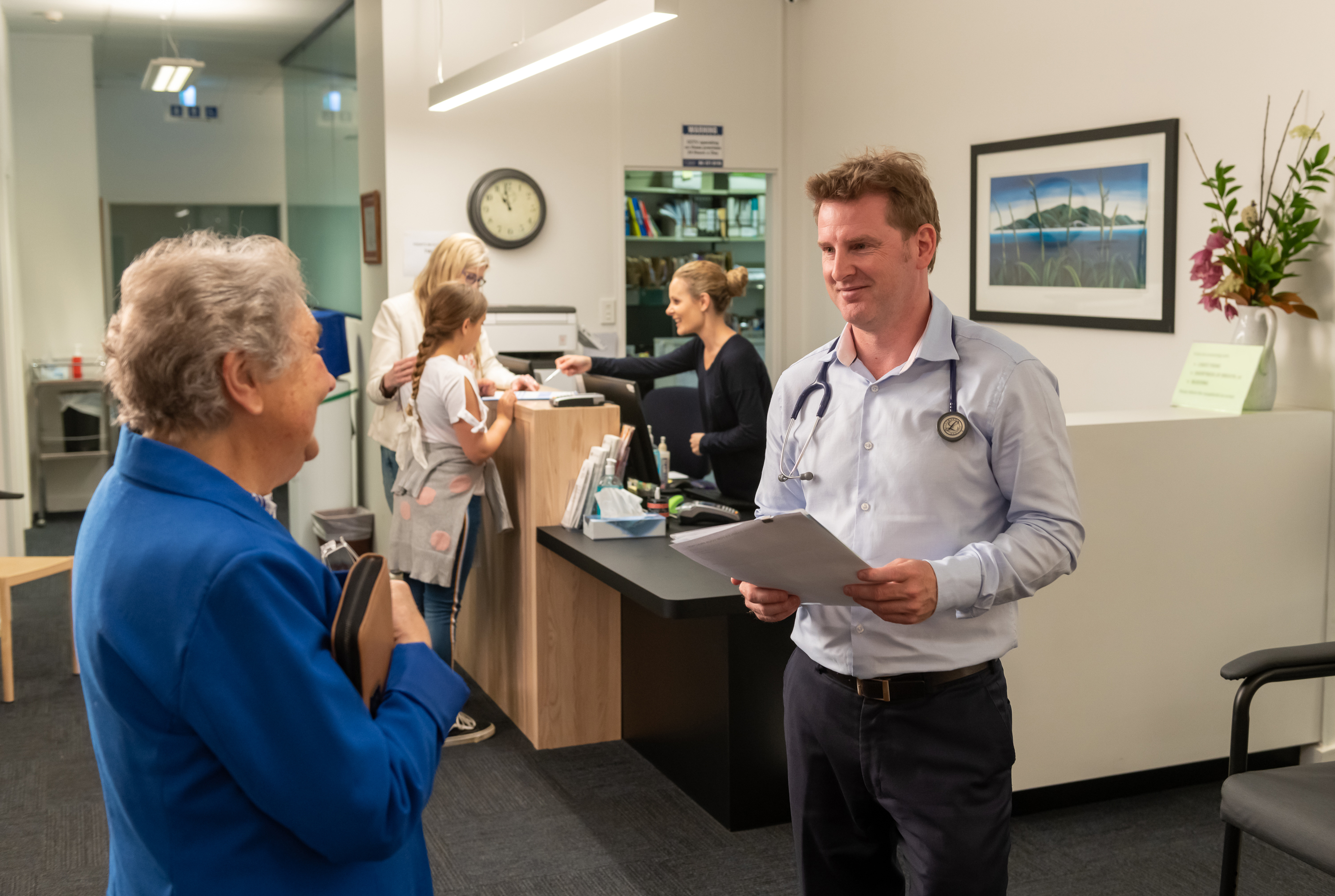 Provider talking to patient holding notes in hand