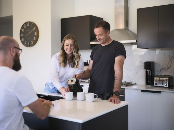Three people talking at kitchen table
