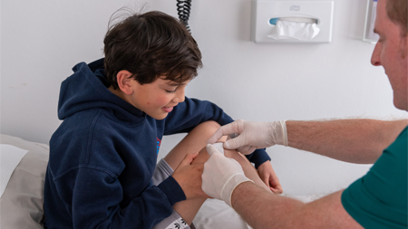 Health provider performing first aid on child