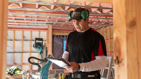 Construction worker reading a tablet device 