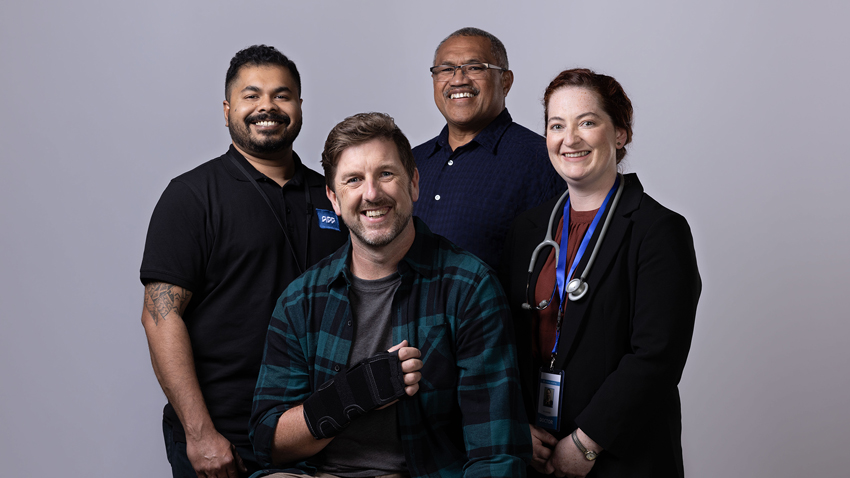 Injured employee with their employer, doctor and ACC person all smiling at camera