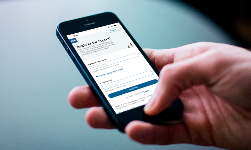 Hand holding mobile phone with Register for MyACC on screen