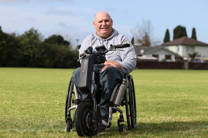 Brendan Tourelle sitting in his wheelchair in a park.