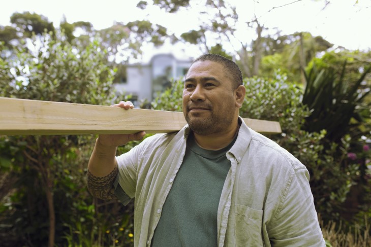 A man carrying a plank of wood. 